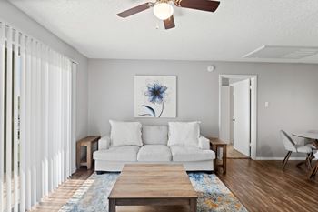 A living room with a white couch and a ceiling fan.